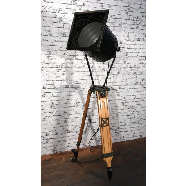 - Industrial spotlight on wooden tripod - Adjustable height and angle - Black metal body - Grey grid - Minimum total...