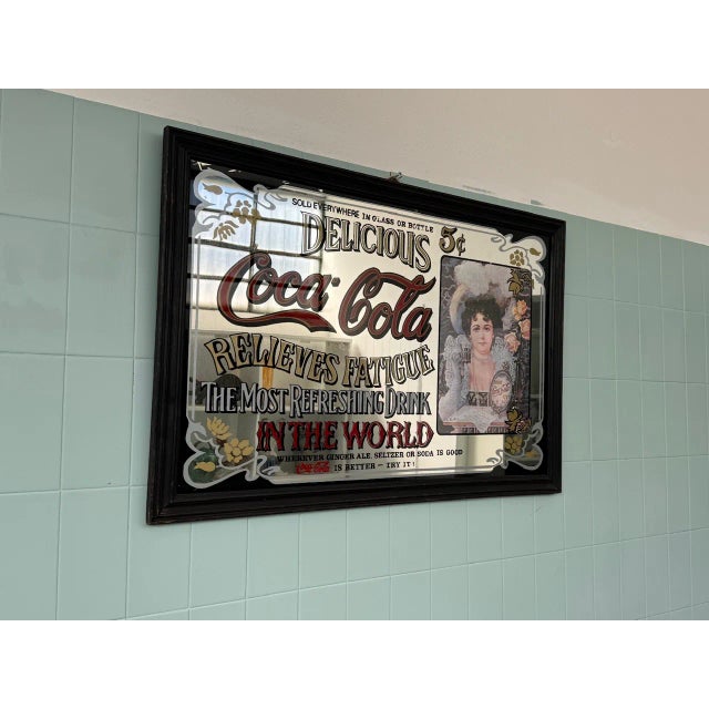 Vintage Coca-Cola advertising mirror with large framed glass. Authentic-looking vintage Coca-Cola advertising mirror,...