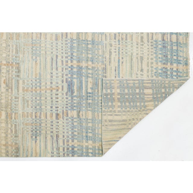 This stunning modern wool area rug features a sophisticated, deconstructed plaid pattern that blends contemporary design...