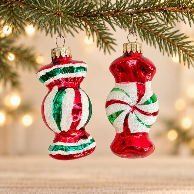 A festive pair of glass Christmas ornaments designed as wrapped candies. Finished in reflective red and emerald green with...