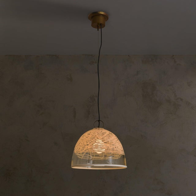 An Italian glass dome pendant from the 1970s, defined by its softly graphic surface. The shade is blown in clear glass and...