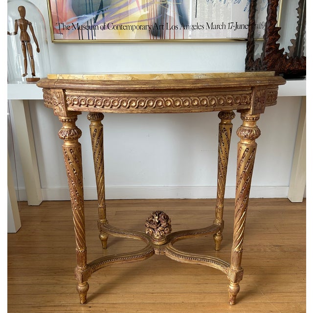 This elegant French Louis XVI Style table features a removable oval marble top and is adorned with various carved...