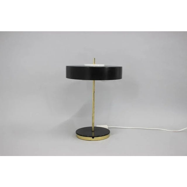 - US plug adapter included. - Good original condition with some signs of use. This piece is attributed to the mentioned...