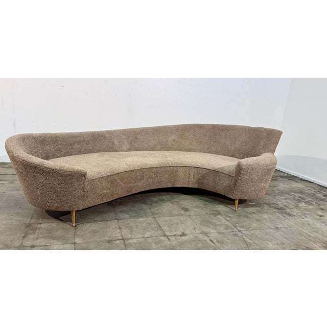This refined curved sofa, attributed to Federico Munari, features a softly sculpted silhouette with gently flared arms and...