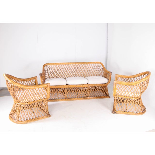 Exceptional 1970s rattan lounge set comprising a sofa and two armchairs. Remarkable craftsmanship of the twisted rattan on...