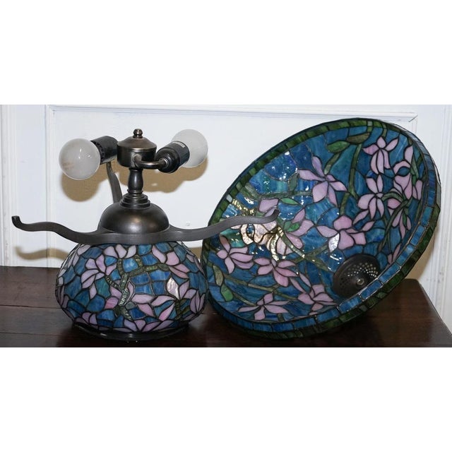 A striking Tiffany-style table lamp inspired by the Art Nouveau era, this exquisite piece features a handcrafted stained...