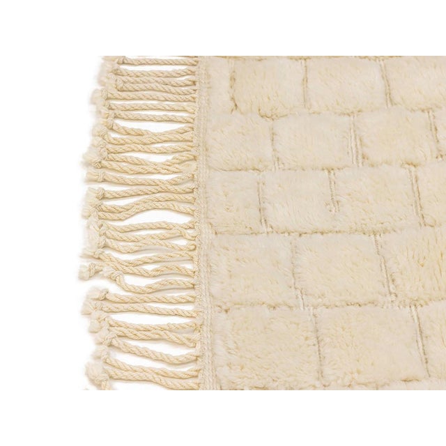 Luxurious hand-knotted wool rug with a textured flat woven checkered pattern in Ivory color, a timeless design offering...