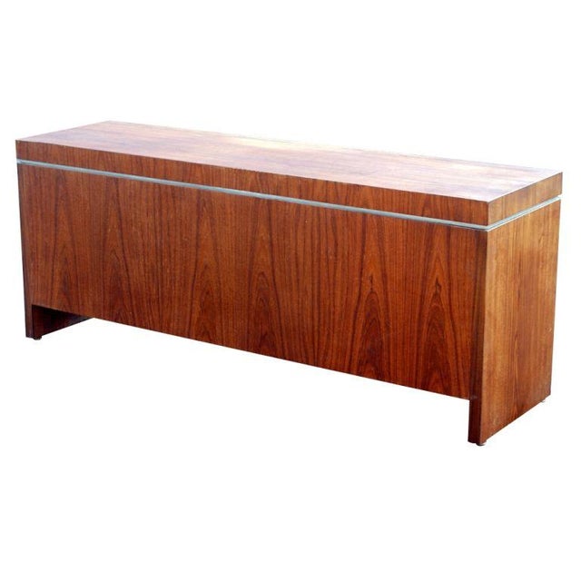 A mid century modern kneehole credenza made by Helikon. Rosewood with decorative chrome detailing. Four storage drawers...