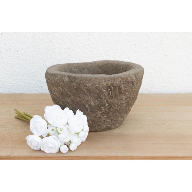 This heavy stone mortar is a relic of the "Old World" kitchen. Carved from a single block of solid granite, it was...