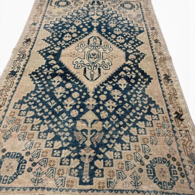 This elegant antique Qashqai rug, handwoven over 100 years ago, showcases a beautifully balanced composition with a...