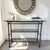Elegant and distinctive, this vintage-inspired console table features a bronzed metal faux-bamboo frame accented by...