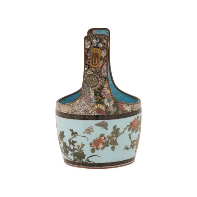 A Japanese polychrome enamel bucket with a handle. The ware is enameled with a polychrome design representing butterflies...