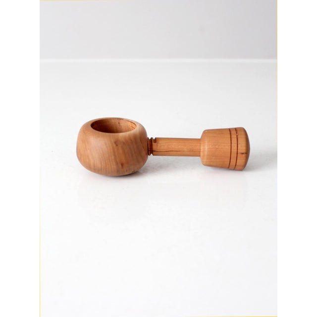 A beautifully sculptural vintage mid-century turned wood nutcracker with a warm natural finish and softly rounded form....