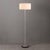 The Slimline Floor Lamp is a modern floor lamp featuring a sleek satin Nickel steel body and base, complemented by a white...