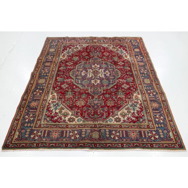 This Vintage Persian Handmade wool rug. This Tabriz rug with red and multicolor accents. This rug measures 6'8" x 9'9".