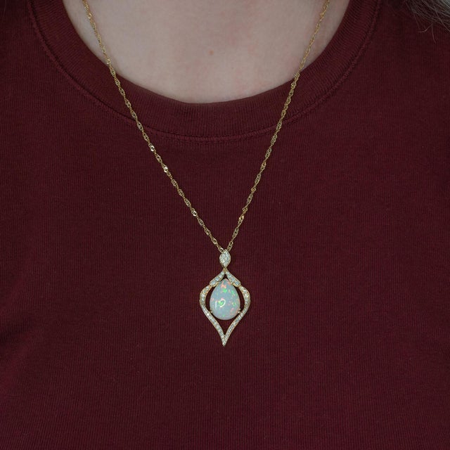 Elegant Ethiopian opal pendant featuring a stunning pear cut 18x13mm natural opal, showcasing a mesmerizing play of color...