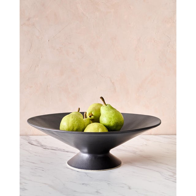 The Large Handcrafted Ceramic Pedestal Bowl by NPage Studio X Lostine is a sculptural decorative vessel that blends...