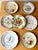 A rare and elegant set of seven antique plates dating from the late 18th to early 20th century, showcasing the refined...