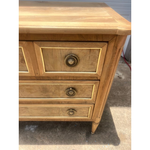 An elegant 19th-century French Louis XVI commode crafted from solid walnut with a beautiful bleached finish that...