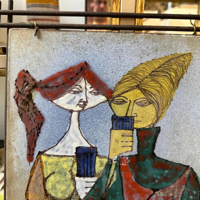This 1950s Mid-Century Modern Italian ceramic plaque, framed in iron, is a vibrant and expressive example of the era's...