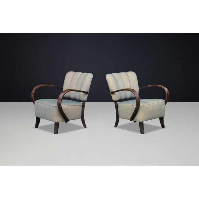 Sculptural Art Deco armchairs by Jindřich Halabala, featuring elegant curved bentwood armrests and original upholstery—an...
