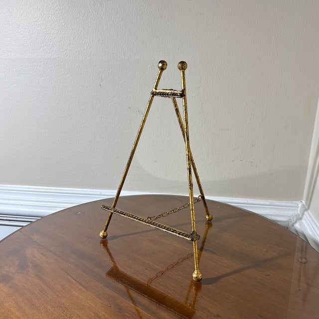 Special gilt Tole table easel with ornate base board, curled feet, and intricate floral detail adorning top. Ball foot on...