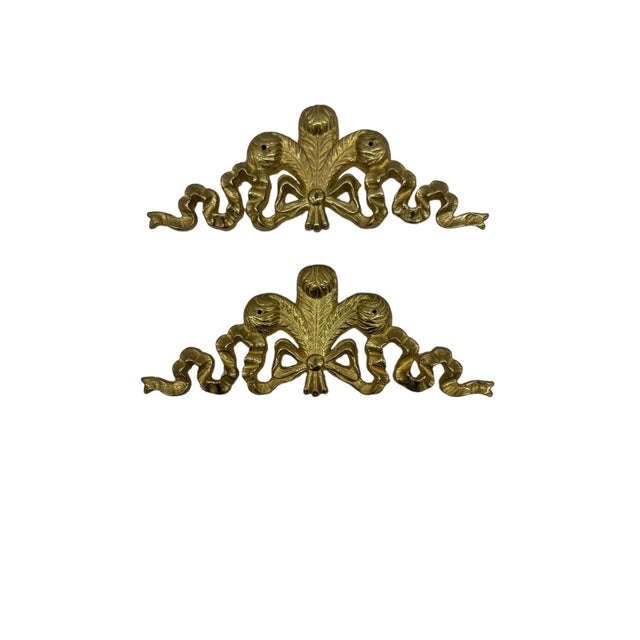 Vintage pair of brass bow swag wall hangings. This elegant solid brass pair is in the form of swags with large bows. A...