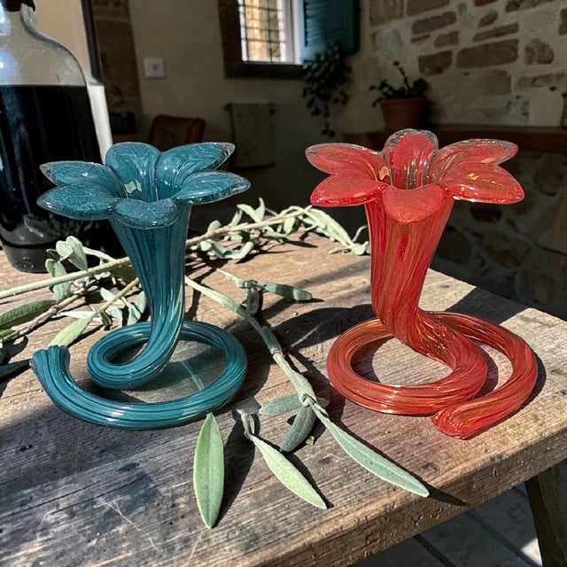 This vintage pair of blue and orange red art glass bud vases features a ruffled flower top and a spiral base, adding a...
