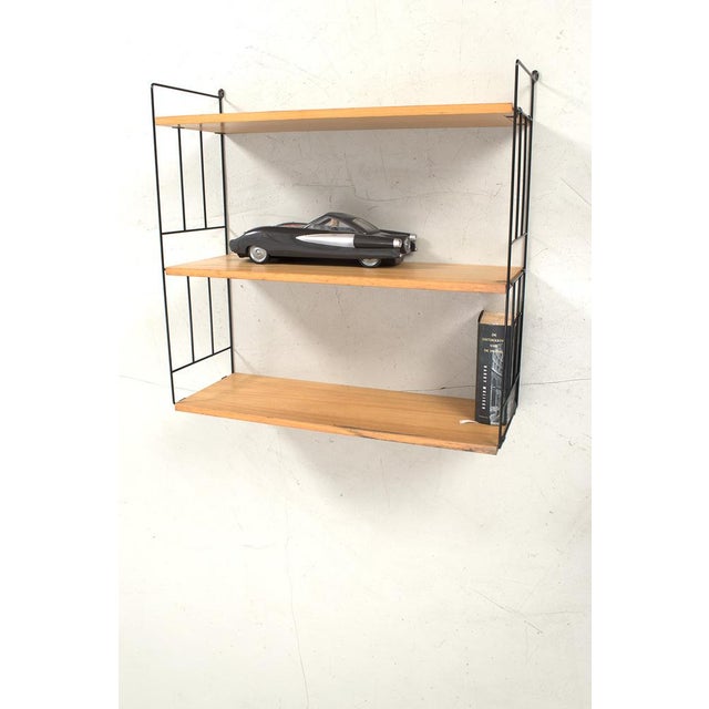 Wire frame wall cabinet with three blonde veneer shelves. It has some traces of use but is still in good vintage...