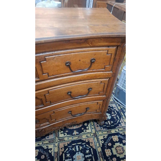 A Louis XV period walnut commode with three drawers. This commode features a slight curve on the front and sides. Period:...