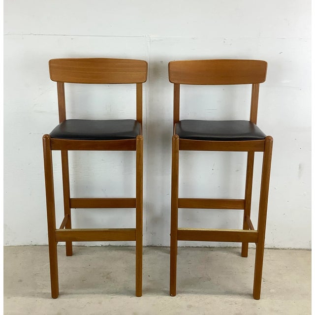 This Pair of Vintage Scandinavian Style Teak Bar Stools from Benny Linden are the epitome of sleek sophistication and...