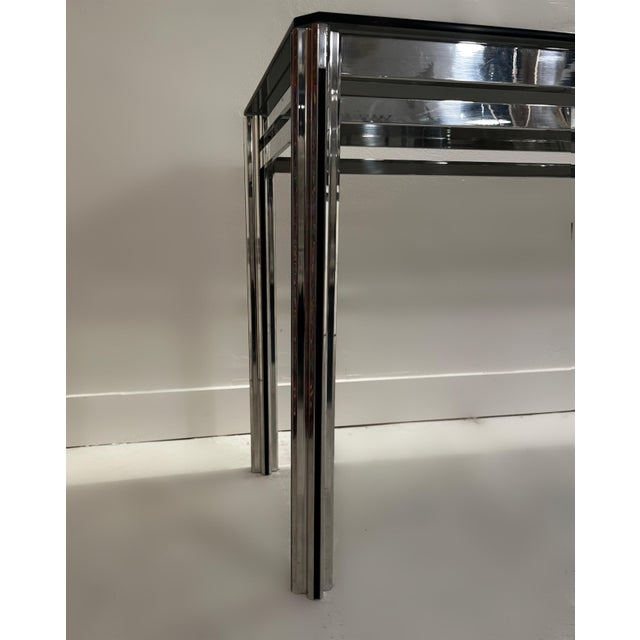 The George Ciancimino chrome and smoked glass console table from 1977 is a striking example of minimalist modernism....
