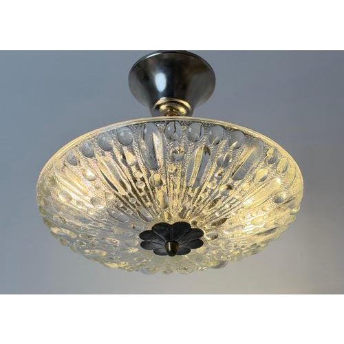 A beautifully proportioned swedish ceiling light, circa 1970, combining richly textured clear glass with a decorative...