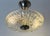 A beautifully proportioned swedish ceiling light, circa 1970, combining richly textured clear glass with a decorative...