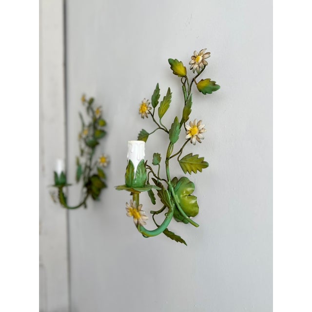 Pair of French tole-painted wall sconces dating to the 1970s. Each sconce features hand-formed green foliage with white...