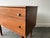 A compact and petite Mid-Century chest of drawers in rich-toned teak, supported on turned teak legs. It has two drawers...