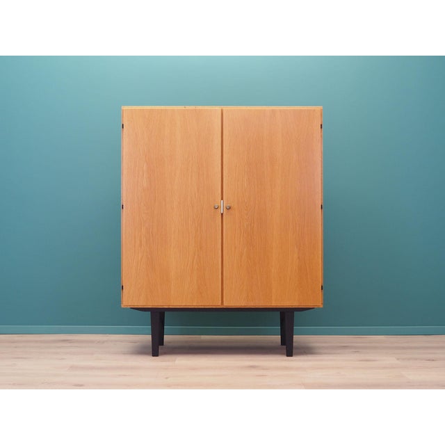 The wardrobe was made in the 1970s, Danish production. The structure is covered with ash veneer. The legs are made of...