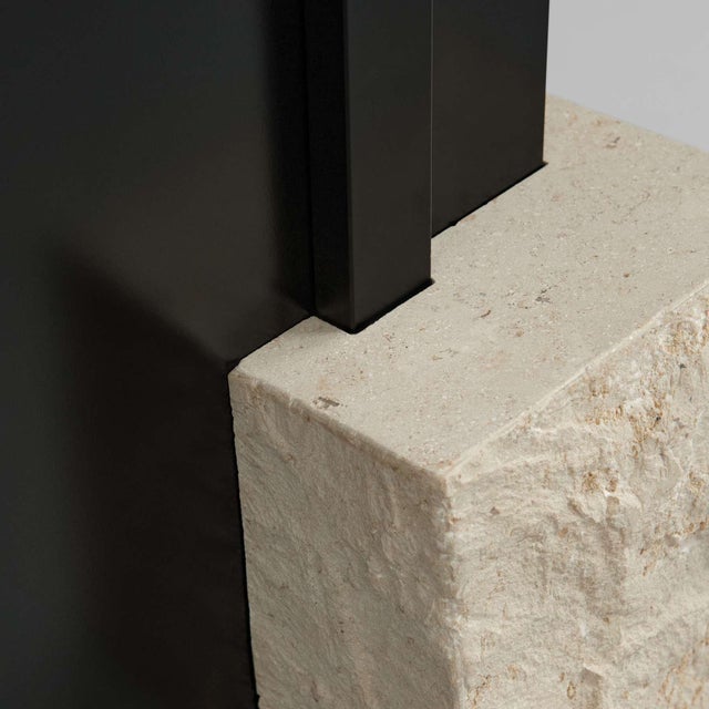 Mirror in limestone and glass, contemporary sculptural design. A slender rectangular mirror rises through a precise cut in...