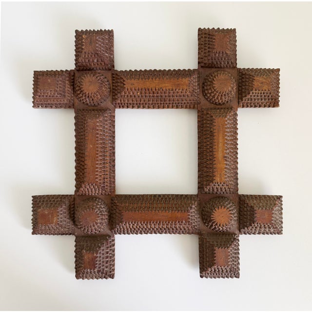 Tramp art picture frame from the late 1800s to early 1900s featuring six layers of chip-carved wood with round chip...