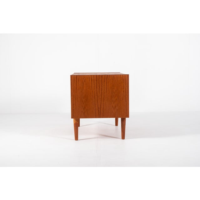 This charming compact sideboard was made in Denmark in the 1960s. It has two sliding doors with beautiful square carved...