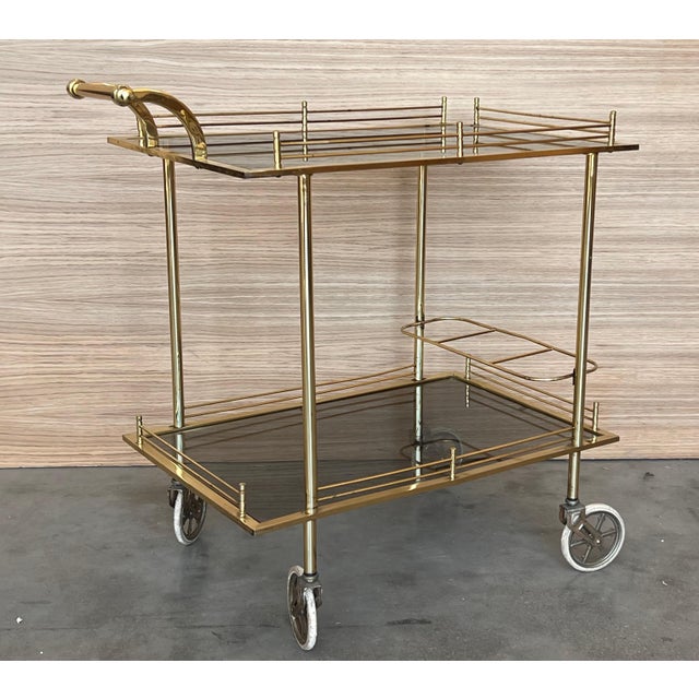 Fabulous brass bar cart with smoked glass Proudly showcase your finest decanters and stemware! Brass handle. This piece is...