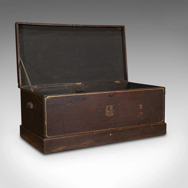 This is an antique merchant's tool chest. An English, stained pine craftsman's trunk, dating to the late Victorian period,...