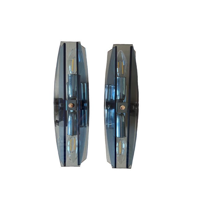 Pair of sculptural glass wall sconces attributed to Veca for Fontana Arte, featuring a sleek, faceted glass fume shade and...