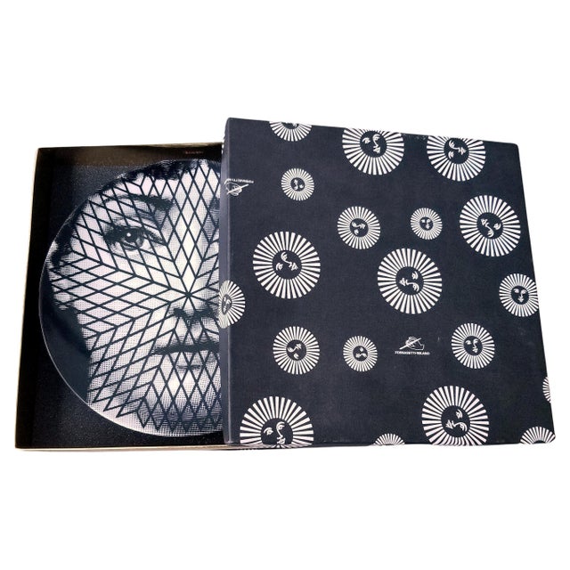 The face of the opera singer Lina Cavalieri, Piero Fornasetti's muse, embellishes this decorative porcelain wall plate....