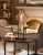 Curvaceous Forged Iron Finished In An Aged Black, Following The Contour Of The Light Amber Glass Shade, Accented With...