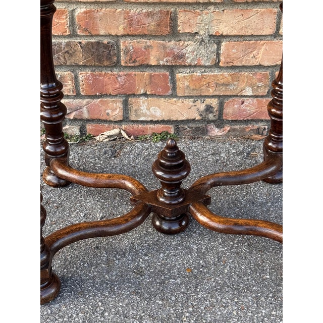 Charming antique wooden side table featuring beautifully turned legs, a single drawer with metal pull, and a sturdy...