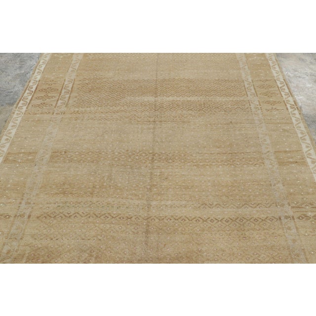 Hand-knotted in wool and originating from Turkey circa 1950-1960, this 6x9 vintage Kars rug is a refined example of...