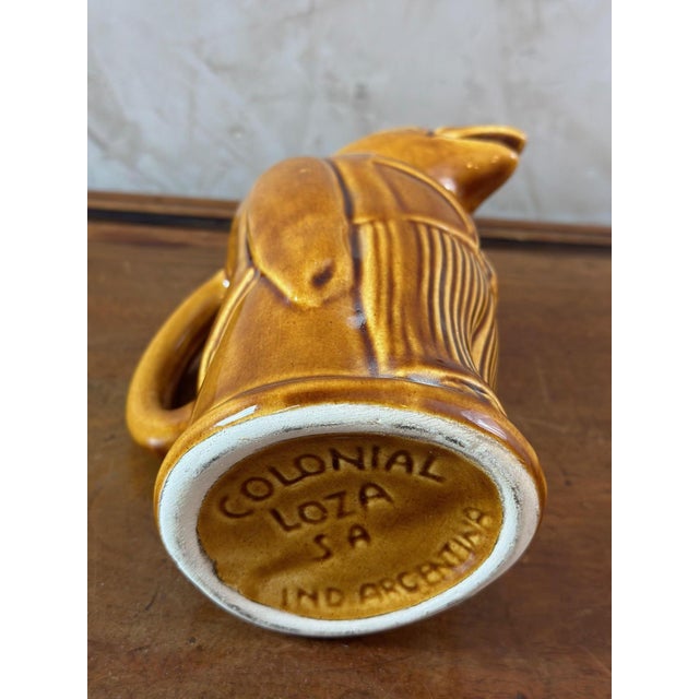Pretty vintage glazed ceramic pitcher representing a crow in men's clothing. Signed below "Colonial Loza Sa Ind...