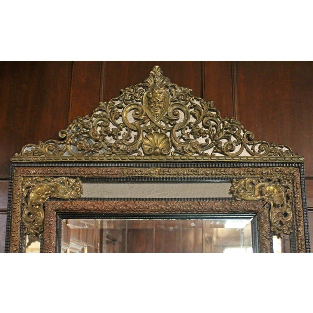 A grand scale French repousse mirror, late 19th century. Traditional "Miroir a Parecloses" form with brass repousse mounts...