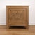 Antique oak side cabinet featuring a door adorned with delicate carved motifs and original brass hardware. Its sturdy...